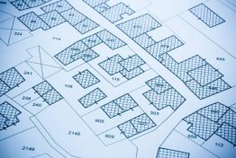 Imaginary cadastral map with buildings, land parcel and vacant plot printed on paper